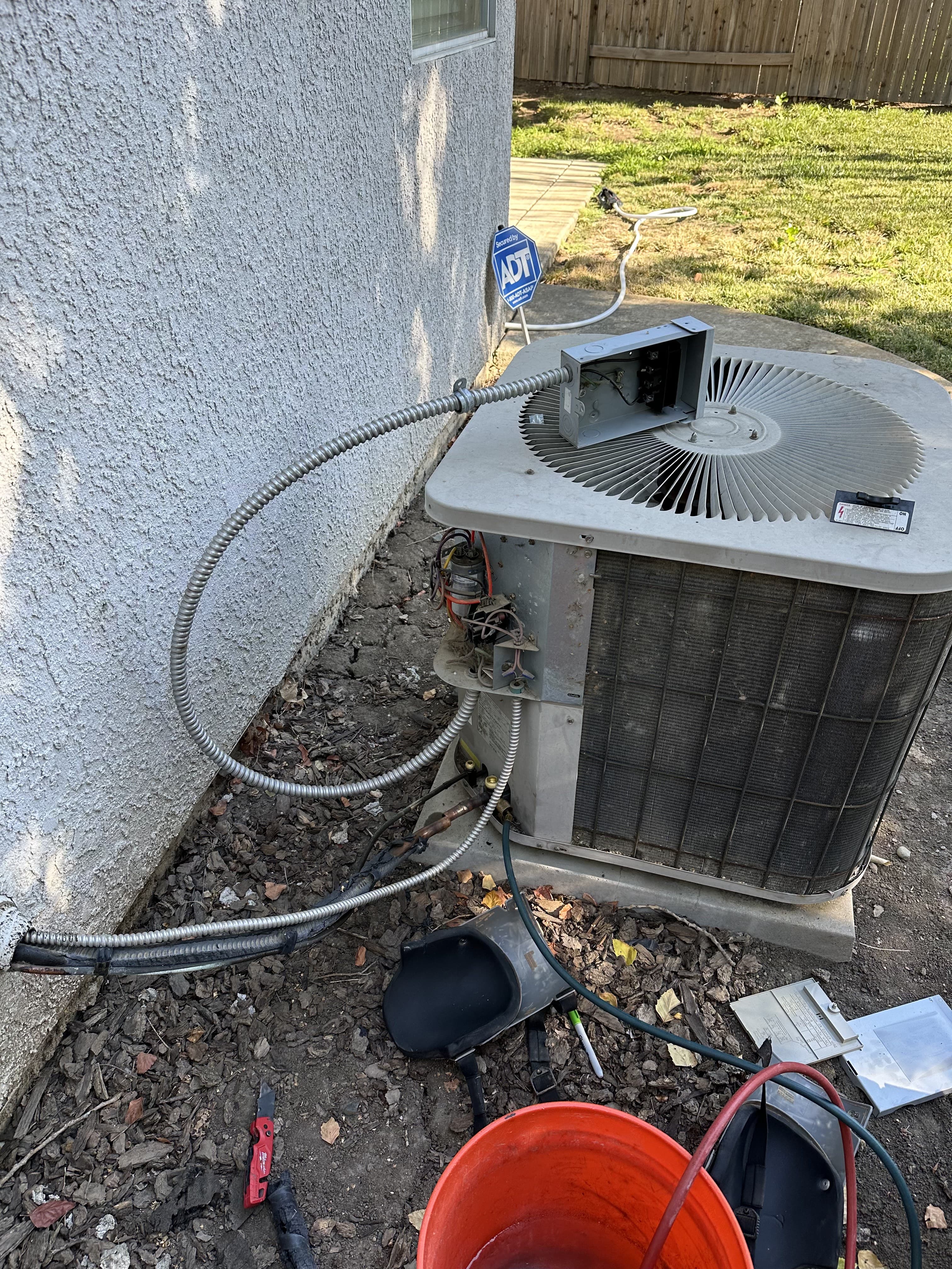 Enright technician diagnosing an AC unit with the side panel removed